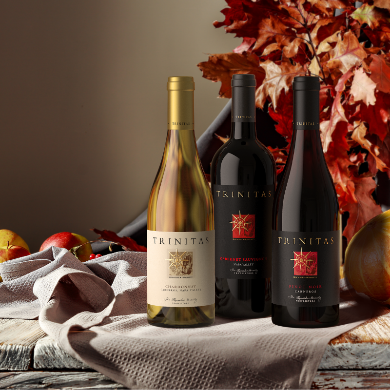 3 bottles of trinitas wine with fall decor