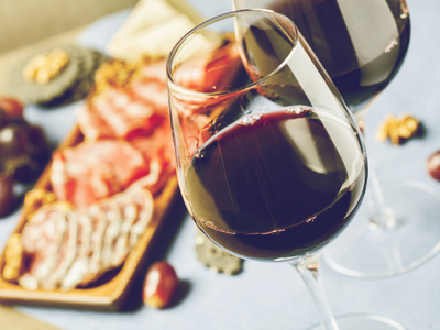 Two glasses of red wine with charcuterie plate