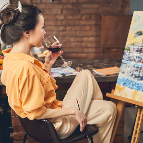 Women drinking wine while painting