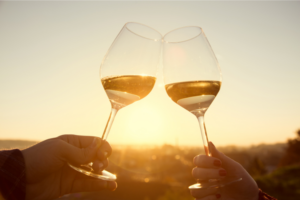 two white wine glasses toasting