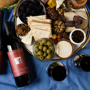 Image of cheese platter with bottle of Trinitas wIne