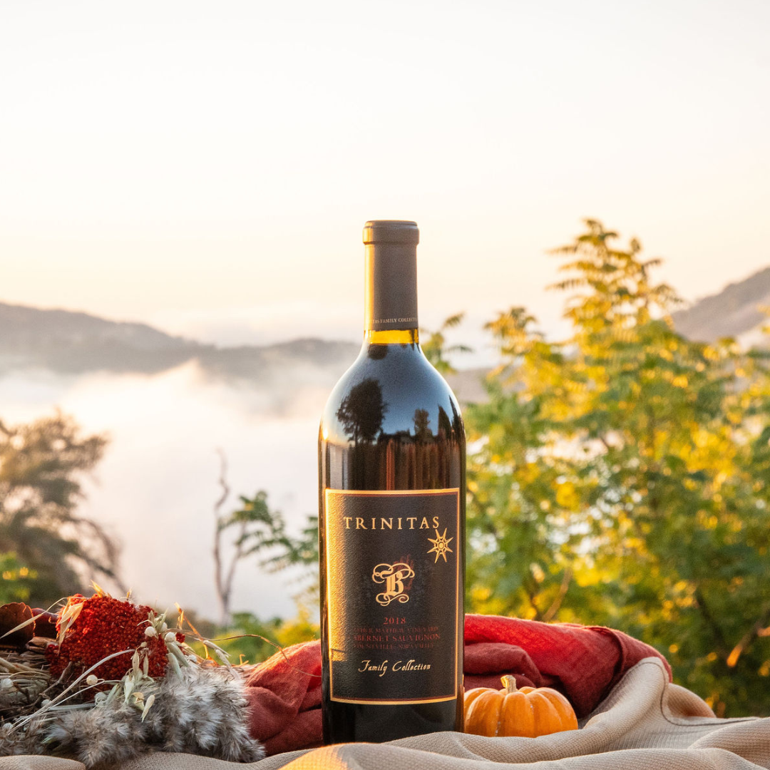 Trinitas Single Vineyard Cabernet Sauvignon bottle at sunset with fall harvest decor